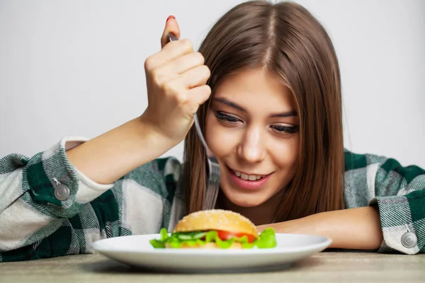 Bella ragazza vuole mangiare hamburger dannoso — Foto Stock