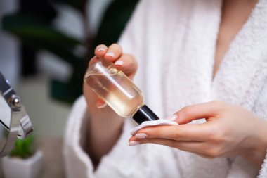 Kız yüz bakımı için losyon sürmüş.