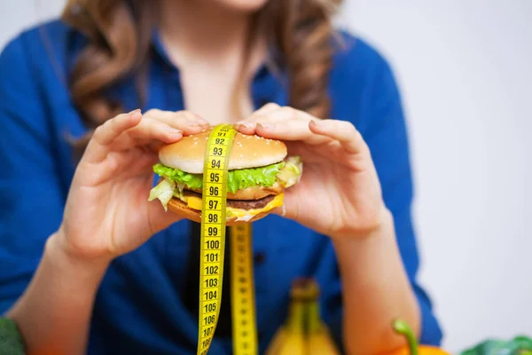 Concetto di alimentazione sana, hamburger con metro a nastro giallo — Foto Stock