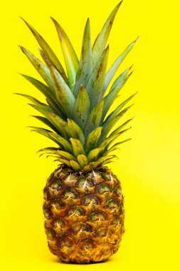 Sarı bir arka plan üzerinde olgunlaşmış taze ananas