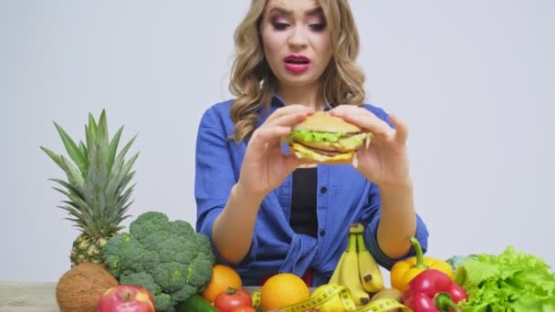 Έννοια της υγιεινής διατροφής, μια γυναίκα που κατέχει ένα burger επιβλαβές — Αρχείο Βίντεο