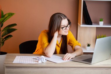 Ofiste dizüstü bilgisayarda çalışan başarılı bir iş kadını.