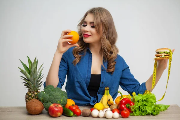 Concept of healthy eating, burger with yellow tape measure and orange. — Stock Photo, Image