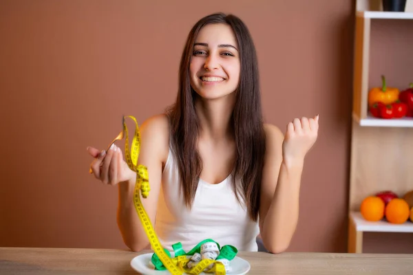 Mulher bonito em uma dieta segurando uma placa cheia de fita — Fotografia de Stock