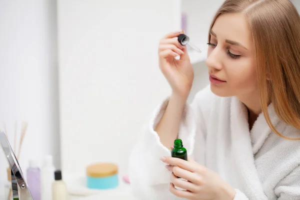 Mulher se preparando para o trabalho fazendo maquiagem matinal no espelho do banheiro em casa . — Fotografia de Stock