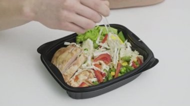 Formda Adam antrenmandan önce elinde bir kase taze salata ve et tutuyor.