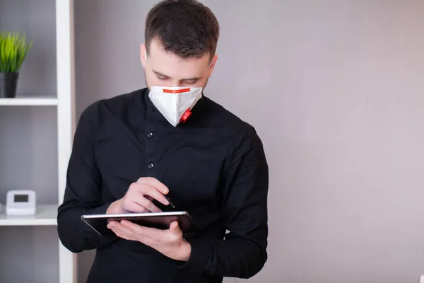 Man working in the office wearing a mask for protection from coronavirus — Stock Photo, Image