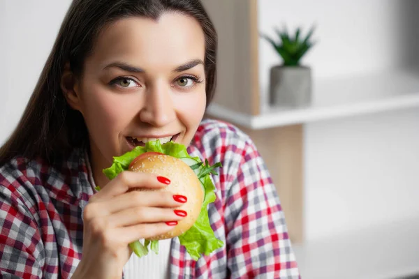 Şirin bir kadın hamburger yemek istiyor. Zararlı. — Stok fotoğraf