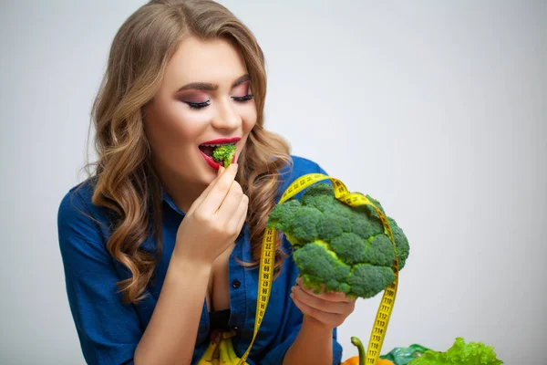 果物や野菜を背景にブロッコリーを持つテーブルの女性 — ストック写真