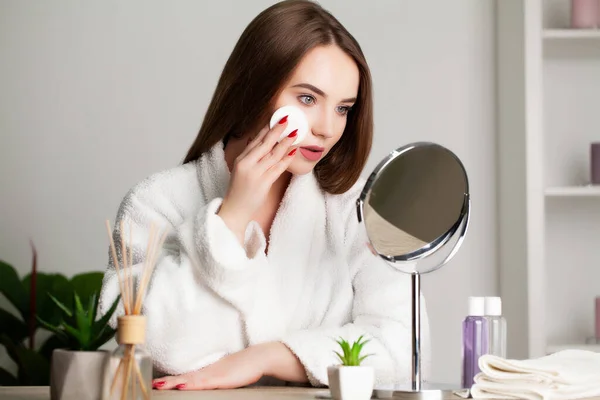 Sevimli genç bayan banyoda yüzüne makyaj yapıyor. — Stok fotoğraf