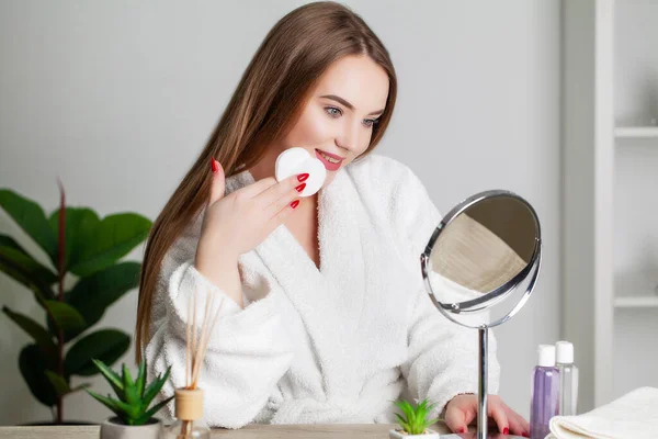 Nette junge Frau schminkt ihr Gesicht im Badezimmer — Stockfoto