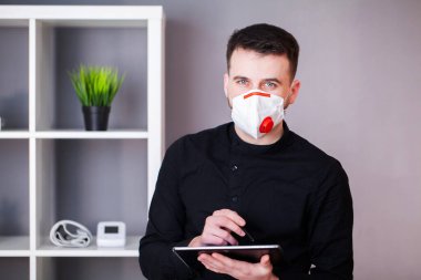 Koronavirüsten korunmak için ofiste maske takan bir adam.