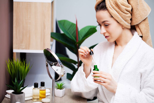 Красивая молодая женщина макияж на лице в ванной комнате