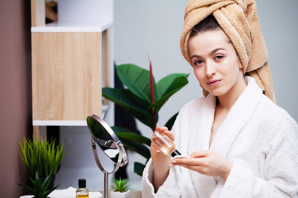 Крупный план девушка кладет лосьон для ухода за лицом на руку
