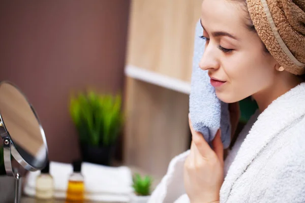 Leuke vrouw veegt het gezicht handdoek na het nemen van een douche — Stockfoto