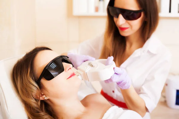 Kobieta robi laserowe usuwanie włosów w studiu piękności — Zdjęcie stockowe