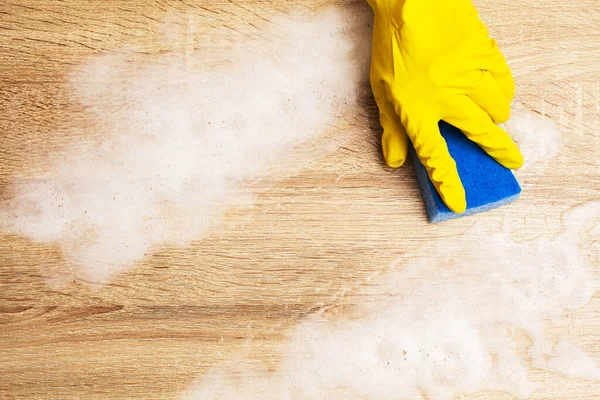 Tutup tangan pekerja menyeka debu di kantor dengan sarung tangan kuning — Stok Foto