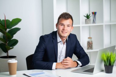 Ceketli sağlam bir işadamı şirketin ofisinde çalışıyor.