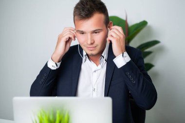 Sağlam bir iş adamı şirket ofisindeki bir müşteriyle telefonda konuşuyor.