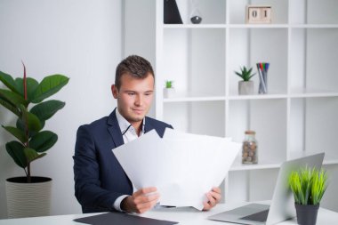 Ceketli sağlam bir işadamı şirketin ofisinde belgelerle çalışıyor.