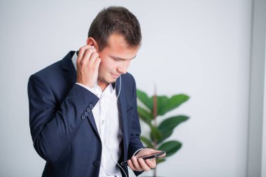 Sağlam bir iş adamı şirket ofisindeki bir müşteriyle telefonda konuşuyor.