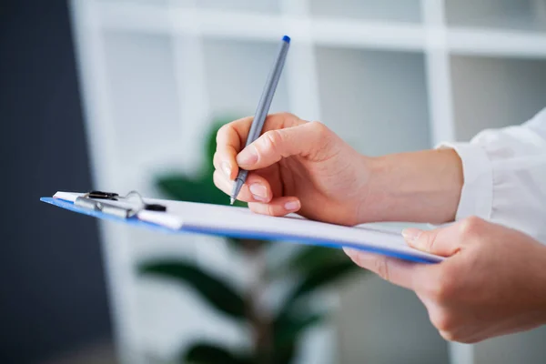 Doctor fills the patients card after examination — Stock Photo, Image