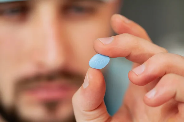 El médico sostiene una píldora para la salud de los hombres —  Fotos de Stock