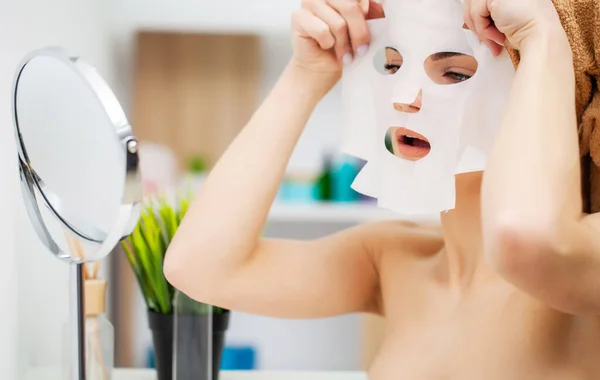 Pretty girl wearing face care mask at home — Stock Photo, Image