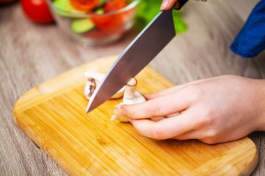 Kadın diyet salatası için mantar doğruyor.