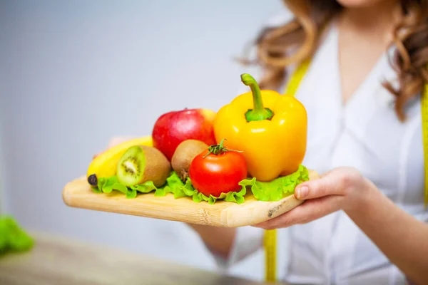 Дієтолог тримає свіжі фрукти та овочі для здорового харчування — стокове фото