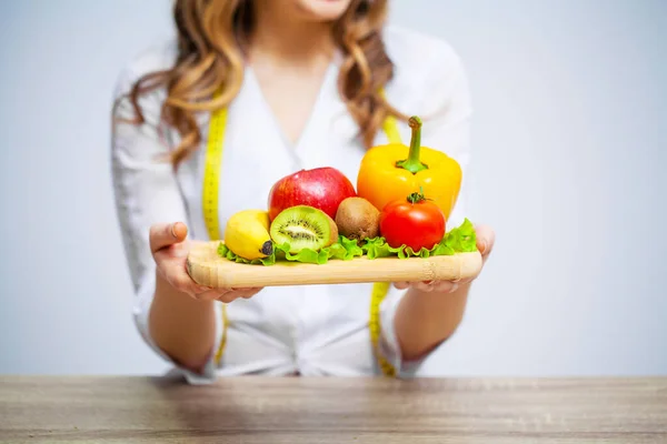 Nutritionist holding fresh fruits and vegetables for healthy diet — Stock Photo, Image