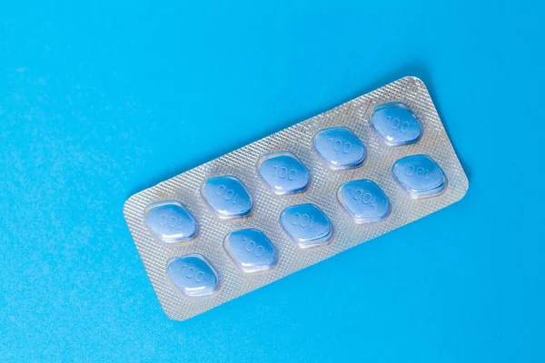 Pastillas para la salud sexual masculina sobre un fondo azul — Foto de Stock