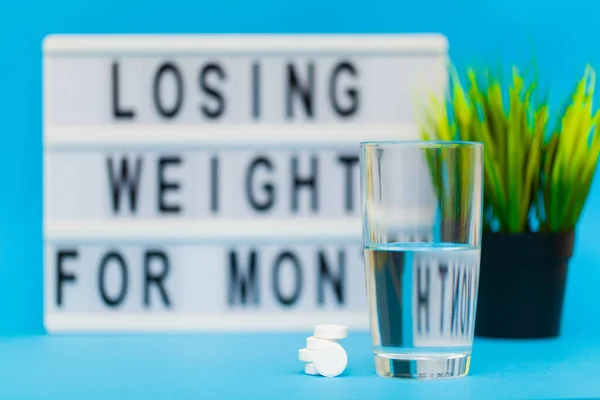 Pills for weight loss on a blue background