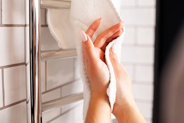 Женщина вытирает руки полотенцем в яркой ванной — стоковое фото