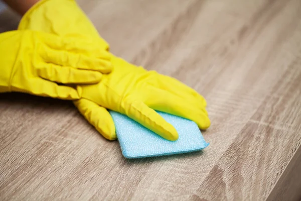 Tutup tangan pekerja menyeka debu di kantor dengan sarung tangan kuning — Stok Foto