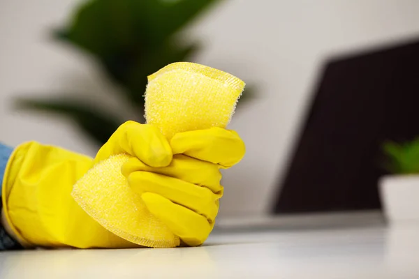 Close up de mão do trabalhador limpando poeira no escritório em luvas amarelas — Fotografia de Stock