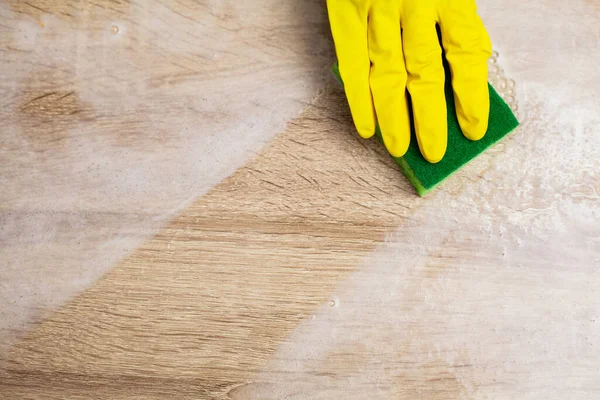 Закрытие рабочих рук, вытирающих пыль в офисе в жёлтых перчатках — стоковое фото