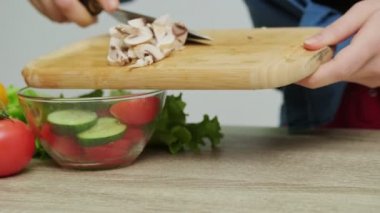 Kadın diyet salatası için mantar doğruyor..