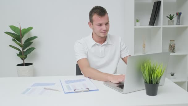 Бізнесмен в білій сорочці працює в офісі компанії на ноутбуці . — стокове відео