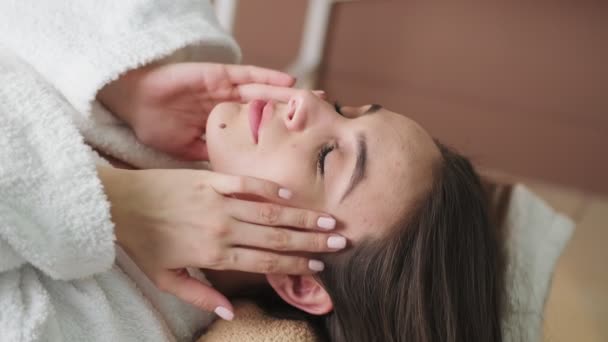Hübsche Frau erhält Gesichtsmassage im Wellness-Salon — Stockvideo