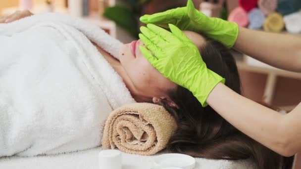 Bella donna che riceve massaggio facciale nel salone spa — Video Stock