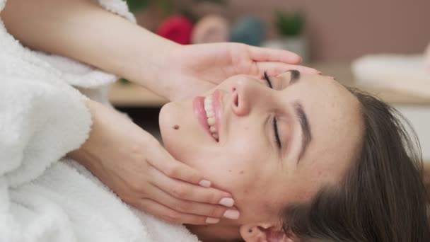 Ładna kobieta otrzymywać masaż twarzy w salonie spa — Wideo stockowe