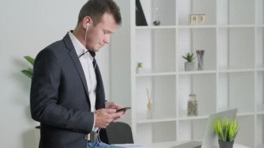Sağlam bir iş adamı şirket ofisindeki bir müşteriyle telefonda konuşuyor..