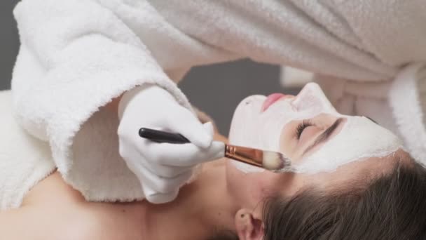 Mulher bonita recebendo máscara facial no salão de spa — Vídeo de Stock