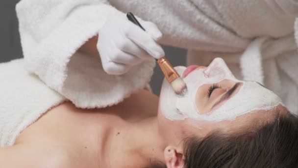 Mulher bonita recebendo máscara facial no salão de spa — Vídeo de Stock