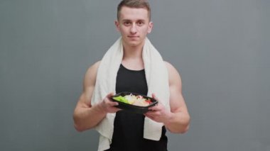 Spor beslenmesi için protein zengini yiyeceklerle dolu bir kutu taşıyan bir adamın yakın çekimi..
