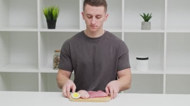 Sporcu bir adam, spor beslenmesi için protein zengini gıdalarla dolu bir tahtayı tutuyor..