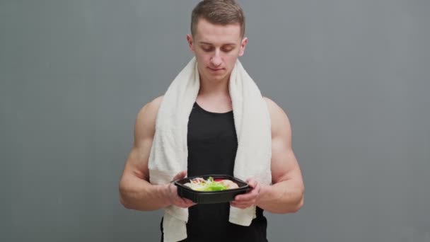 Närbild av en man som håller en låda full av proteinrik mat för sportnäring. — Stockvideo