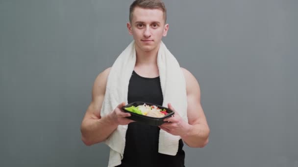 Close-up van een man met een doos vol eiwitrijke voedingsmiddelen voor sportvoeding. — Stockvideo