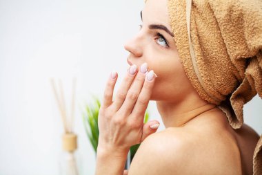 Güzel bir kadın evde yüzüne makyaj yapıyor.